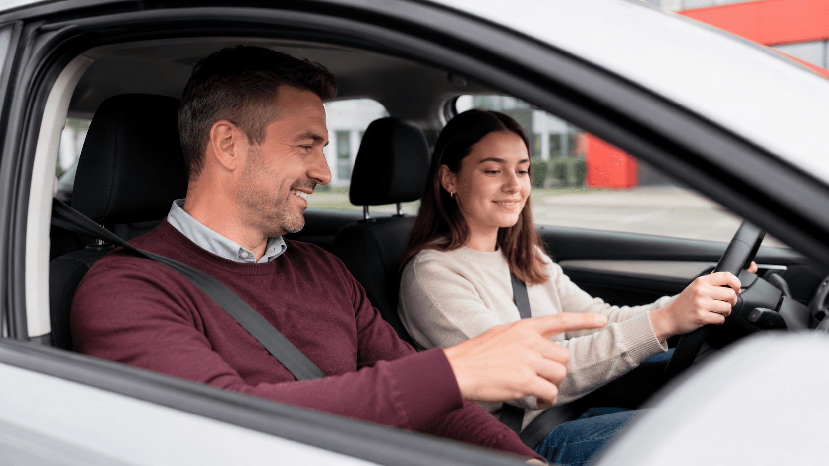 Fahrlehrer begleitet eine Schülerin bei einer Fahrstunde