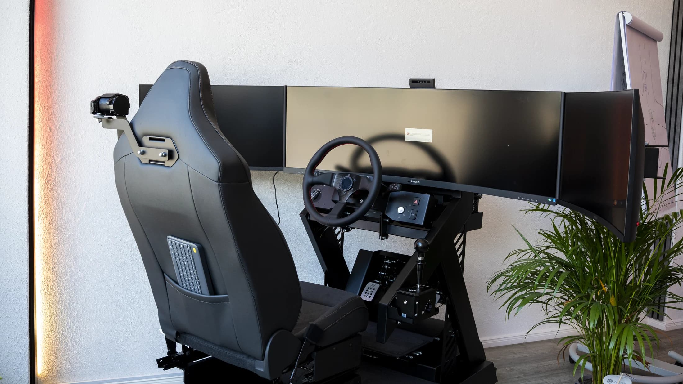 Fahrsimulator von MultiMove mit Sitz, Lenkrad, Schaltung und drei Bildschirmen